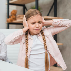 portrait distraught girl covering her ears with two hands
